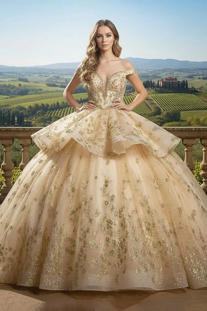 champagne ballgown with an off-the-shoulder neckline and peplum-style ruffled waist, adorned with intricate gold floral lace appliqués, posing against a vineyard balcony.