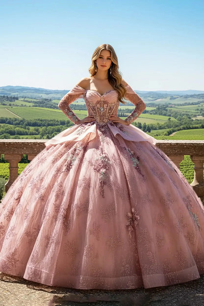 woman with long blonde hair wearing a blush pink off-the-shoulder ball gown with intricate floral embroidery, standing on a stone balcony overlooking a lush green vineyard under a clear blue sky.