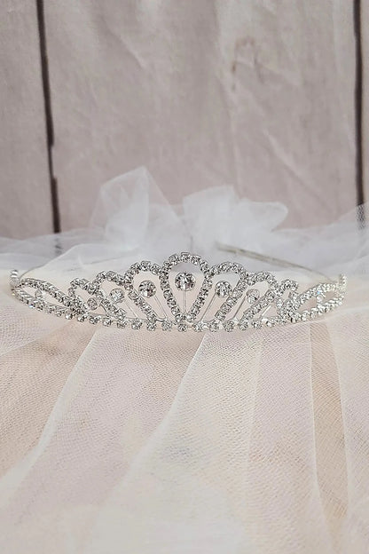 Silver tiara on a white fabric background