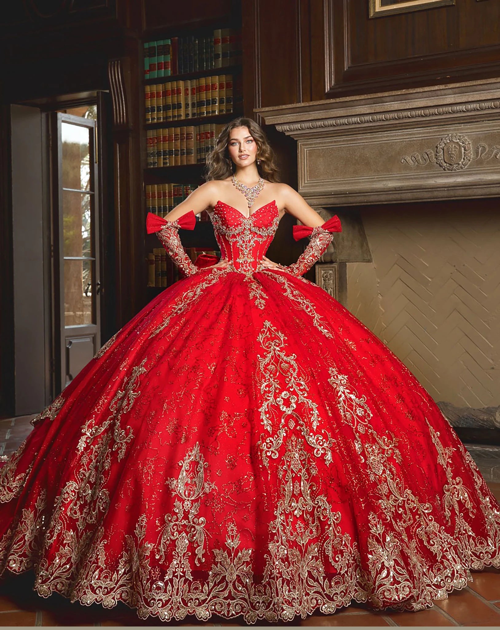 Front view of a girl wearing a red quinceañera gown with gold embroidery, corset bodice and voluminous skirt