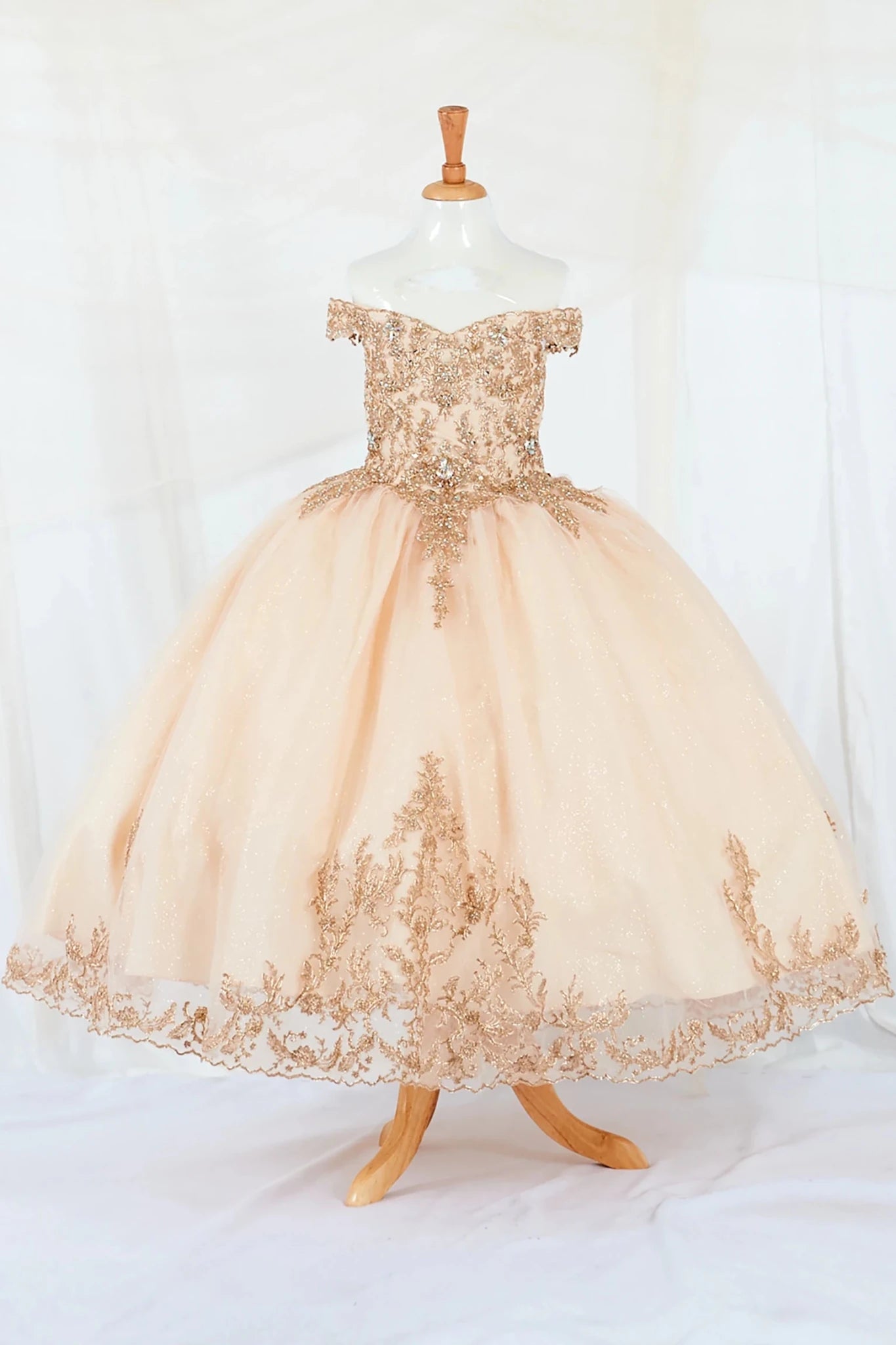 Gold lace mini quince dress with 3d embroidery on a mannequin against a white background