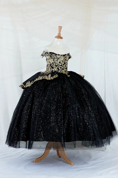 Black kid ball gown off the shoulder dress with gold embroidery on a mannequin against a white background