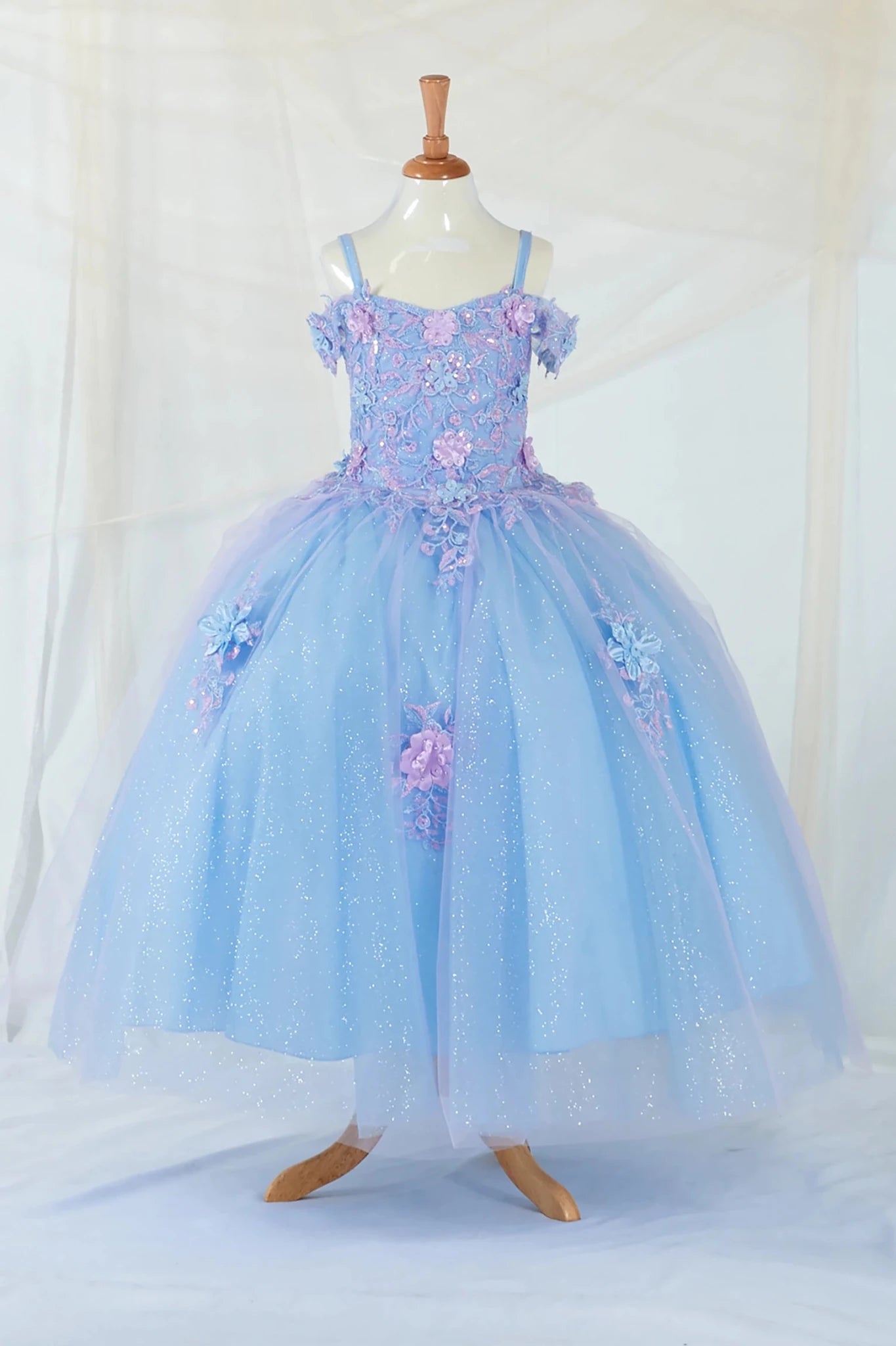 Front-facing display of an elegant light blue and lilac ball gown featuring a 3D floral corset bodice and a glitter tulle layered skirt.