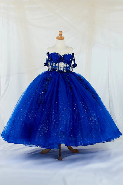 Front-facing display of an elegant royal blue ball gown featuring a crystal-beaded bodice, detachable bow accent, and a glitter tulle layered skirt.