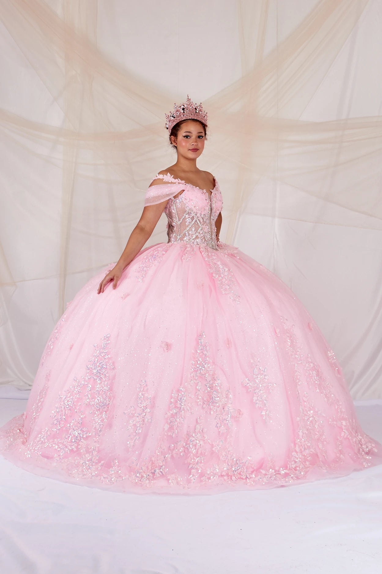 Side view of a woman wearing Soft pink ball gown with beaded bodice floral accents and airy skirt design