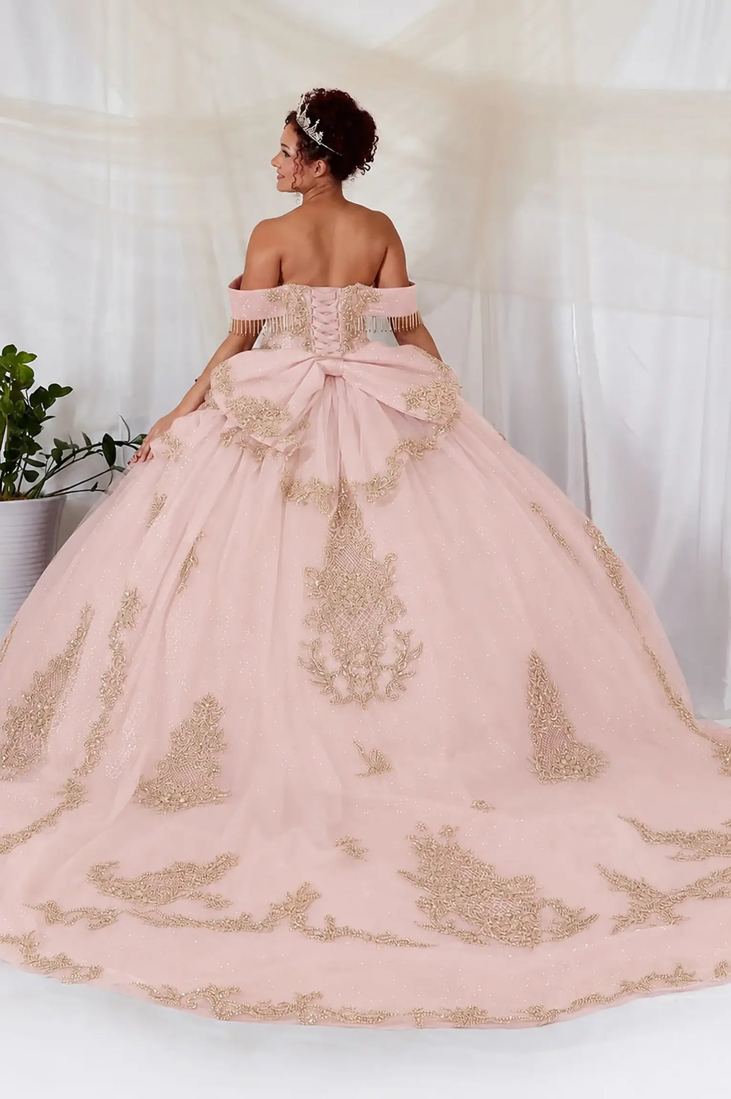 Blush quinceanera ball gown with lace-up corset back, gold embroidery, bead accents, and layered glitter tulle skirt