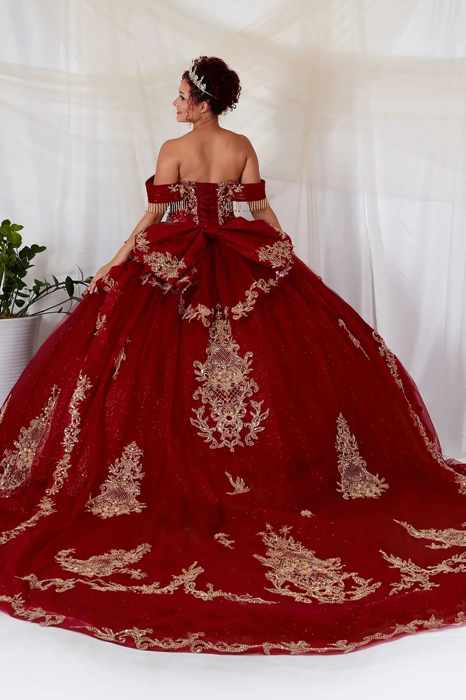 Burgundy quinceanera ball gown with lace-up corset back, gold embroidery, bead accents, and layered glitter tulle skirt