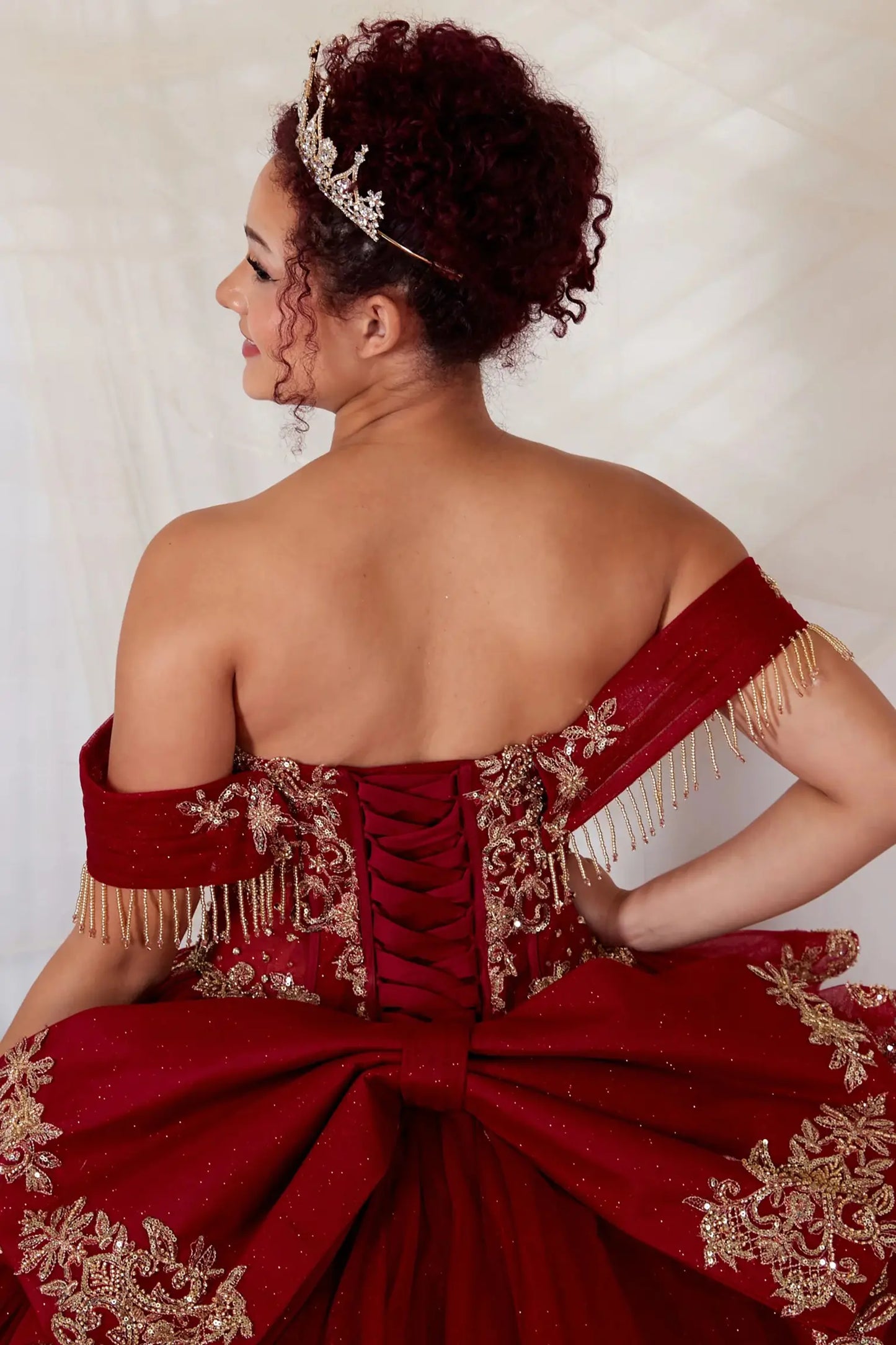 Burgundy quinceanera ball gown with lace-up corset back, gold embroidery and beaded accents