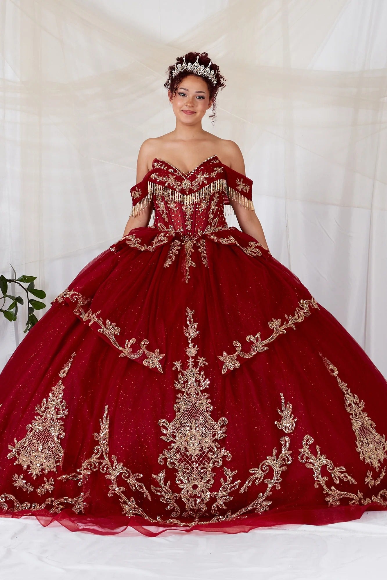 Blush quinceanera ball gown with gold embroidery, bead accents, fringe bodice, and shimmering tulle fabric