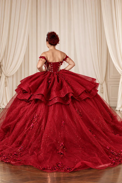 Back of the burgundy quinceañera ball gown showing lace-up corset closure and layered ruffle skirt.