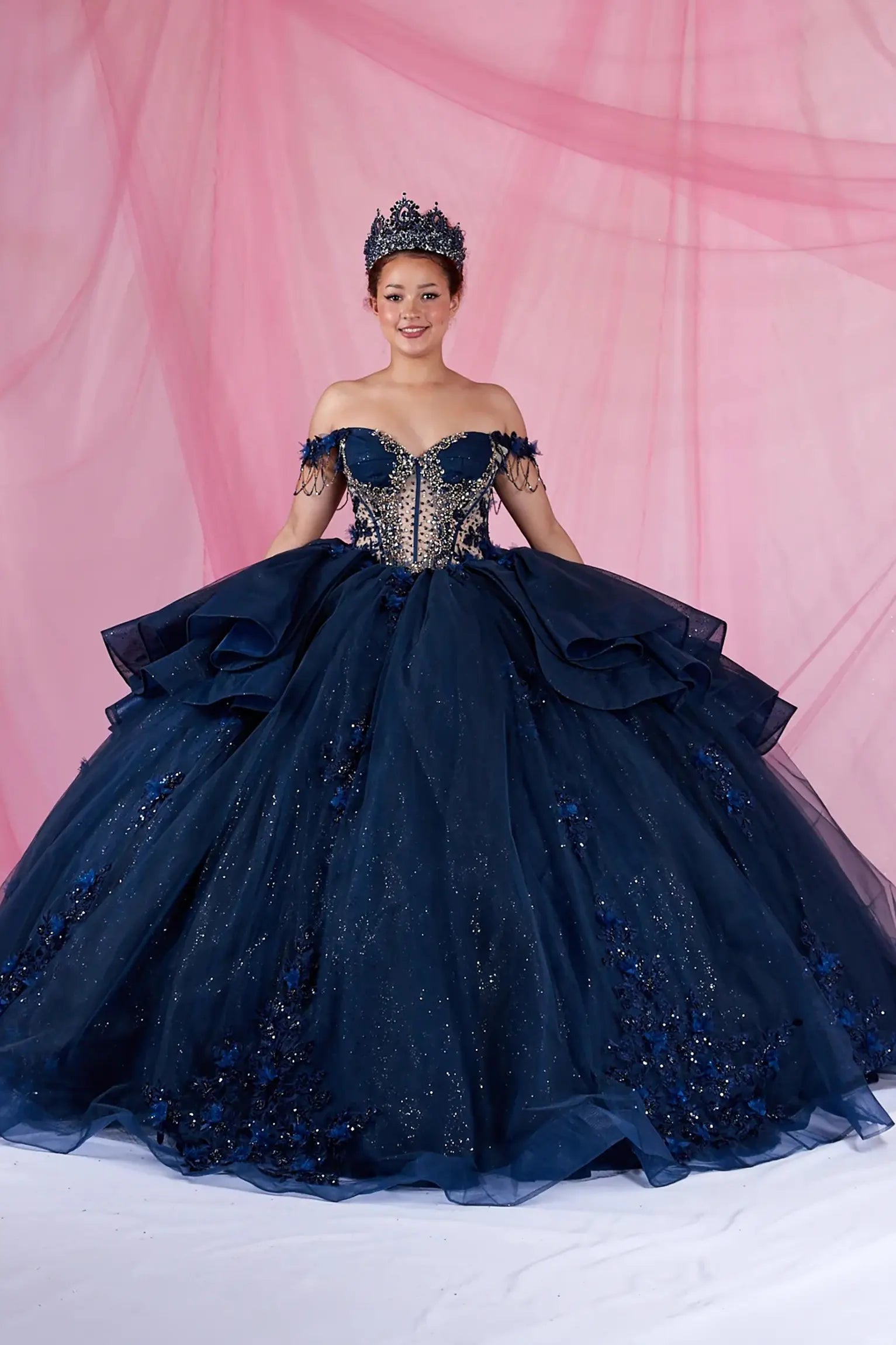 Navy quinceanera ball gown with off-shoulder neckline, bead accents, and glitter tulle skirt