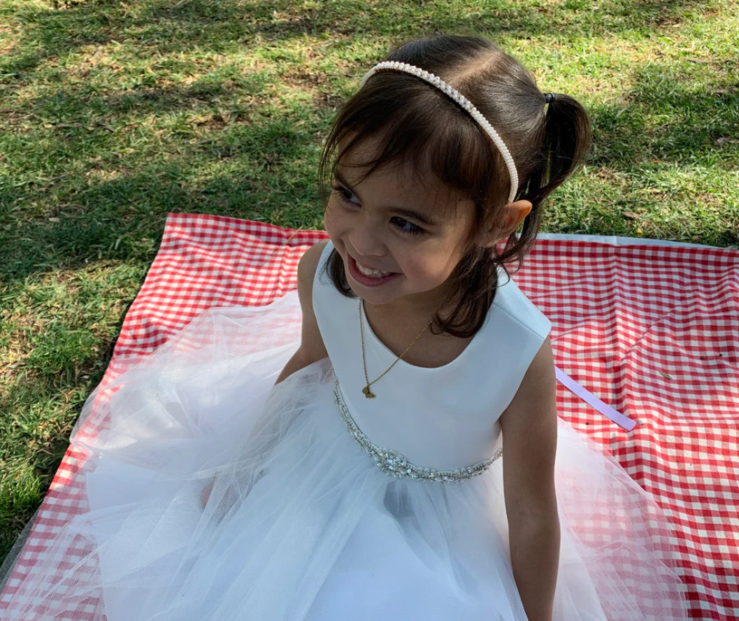 Pearl Rhinestone Flower Girl Kid Headband - girl wearing headband smiling and sitting on a picnic blanket