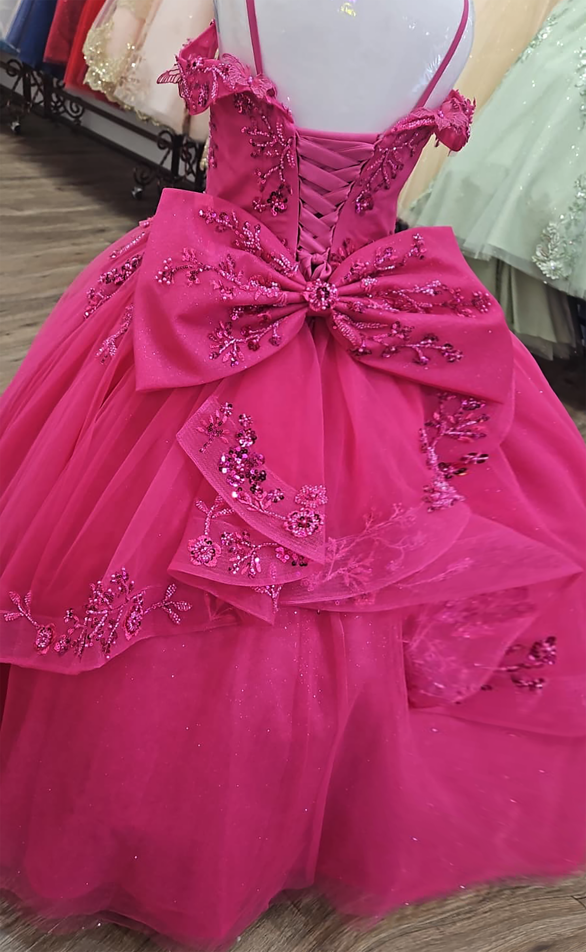 Fuchsia dress with floral embellishments on a mannequin