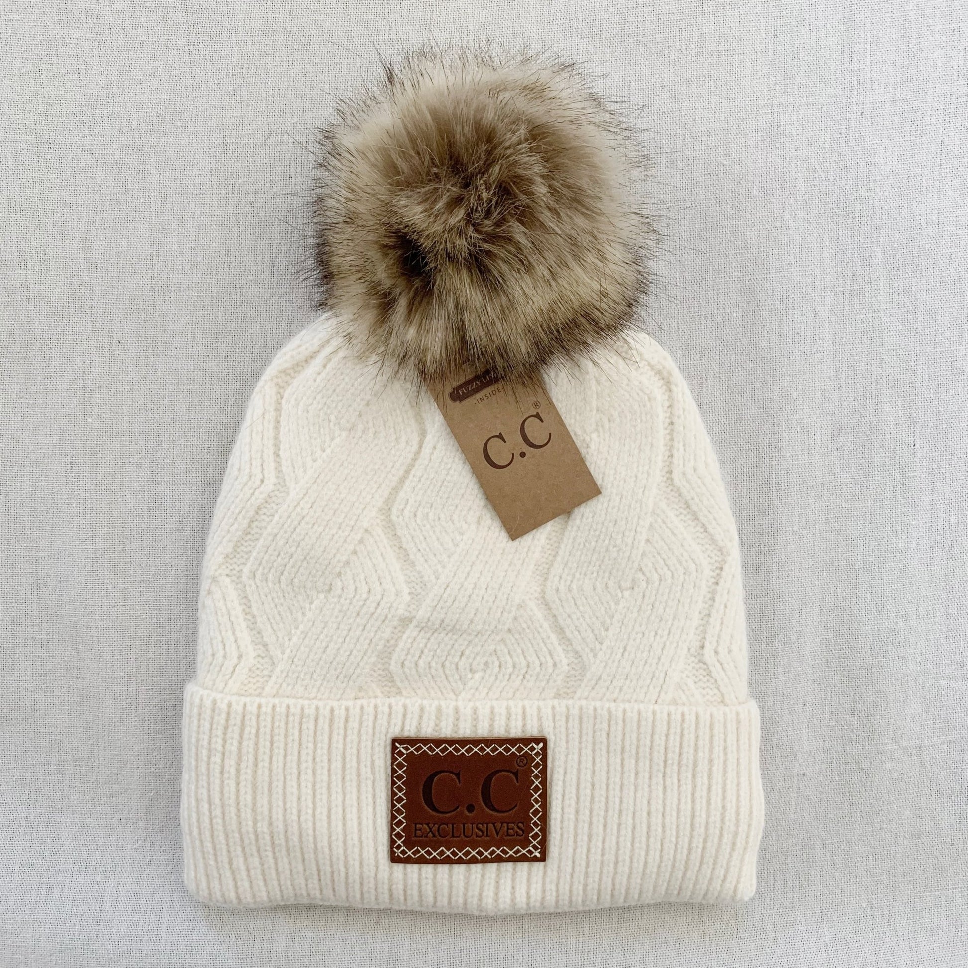 Ivory pom-pom women's winter beanie, interior detail.