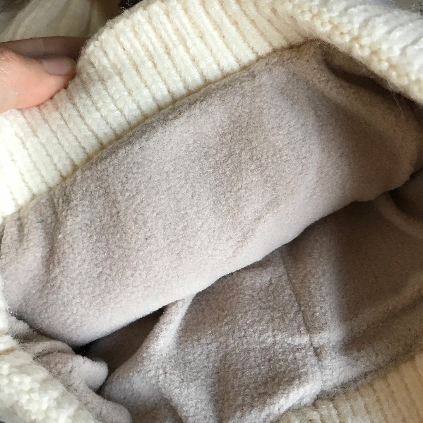Ivory pom-pom women's winter beanie, interior detail.