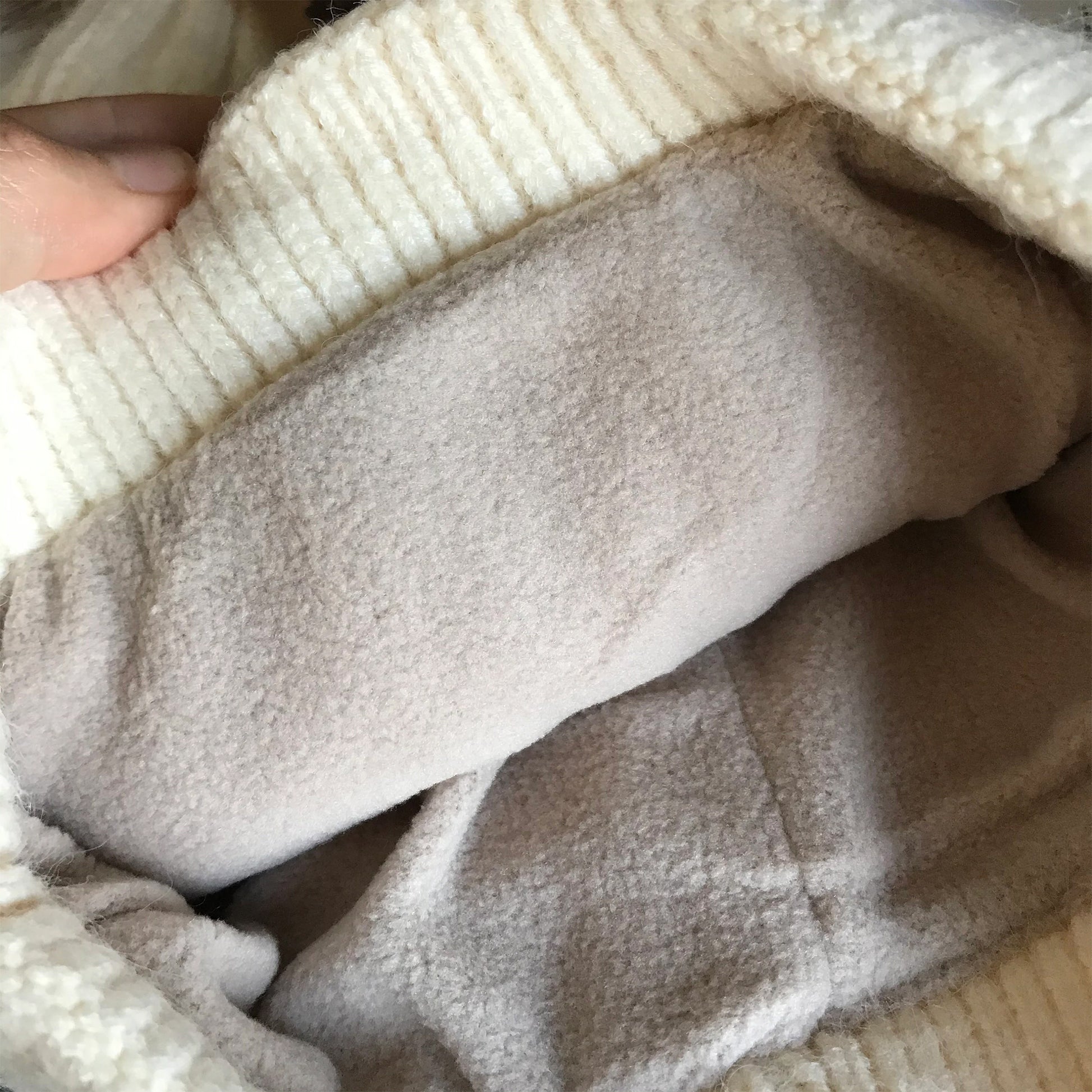Ivory pom-pom women's winter beanie, interior detail.