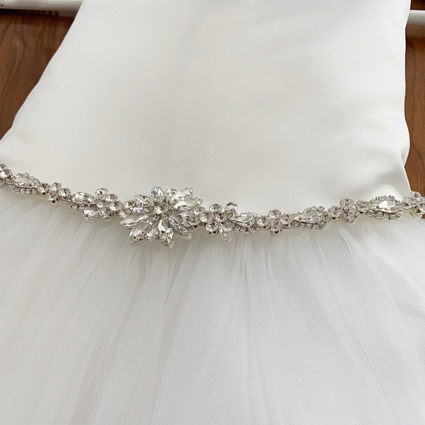 Silver rhinestone floral flower girl sash belt, close-up, embellishment detail.