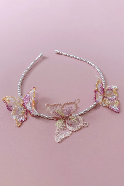 A silver and white beaded headband decorated with three embroidered butterfly appliqués in pastel pink, gold, and cream