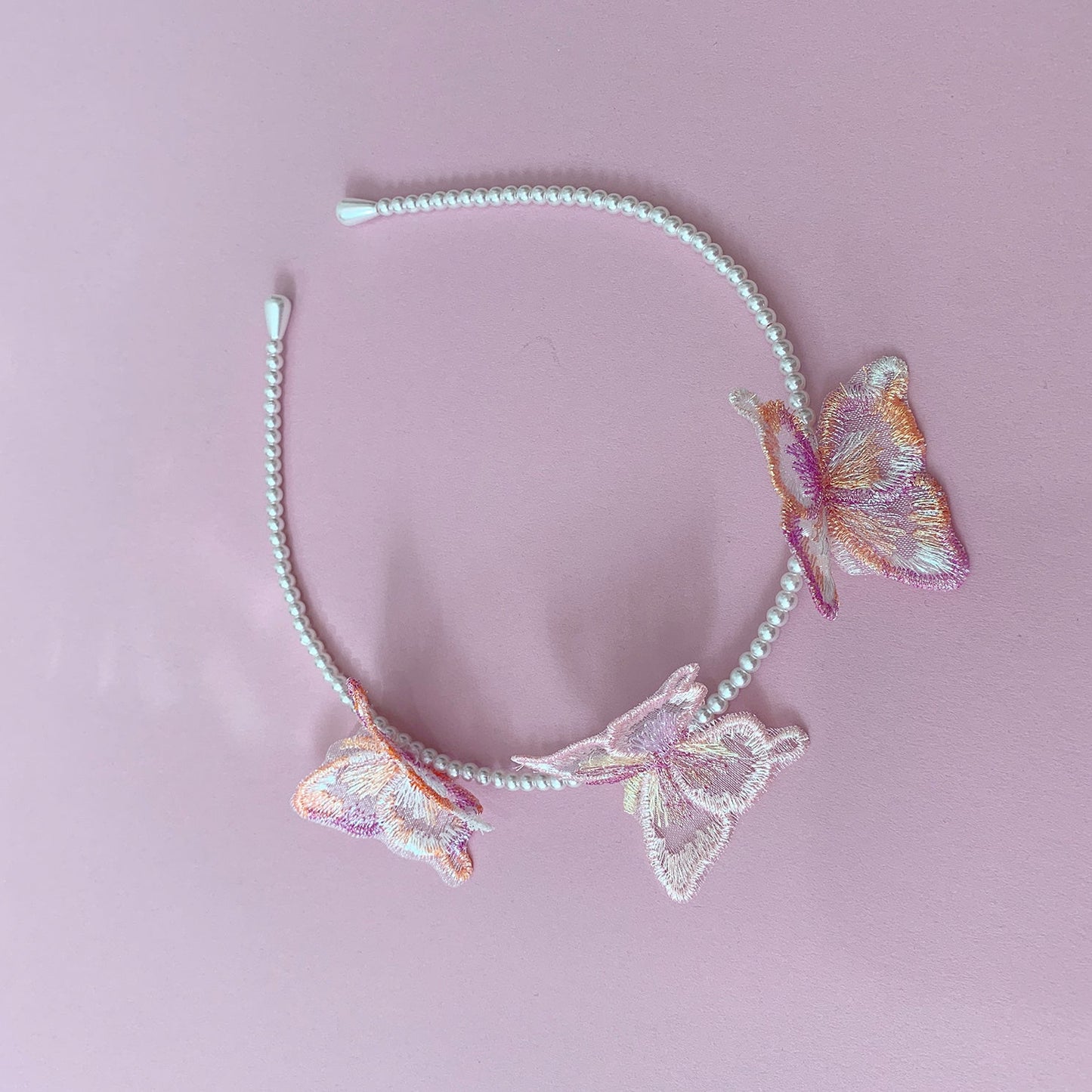Multi color pearl butterfly flower girl headband or hair clips, top view.