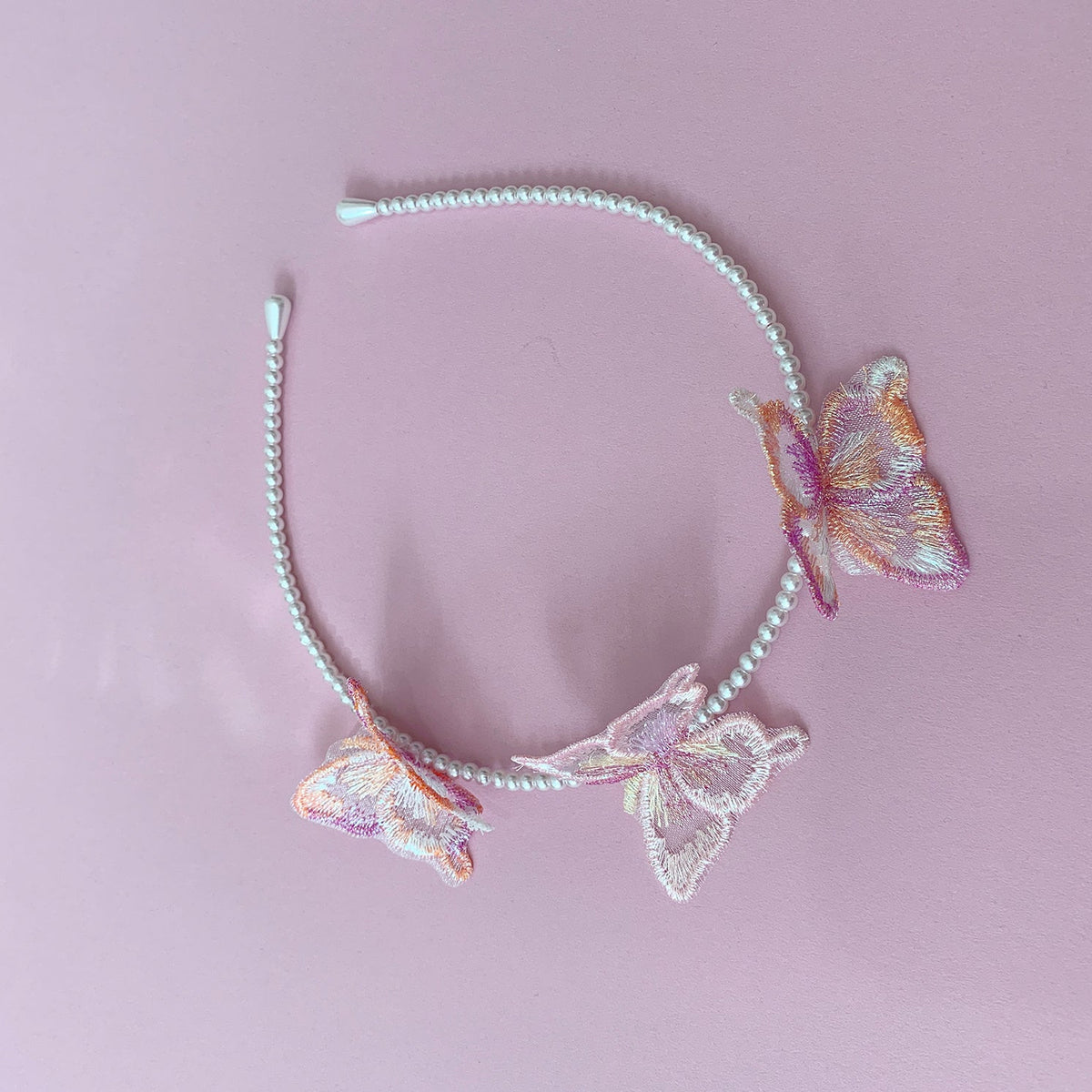 Multi color pearl butterfly flower girl headband or hair clips, top view.