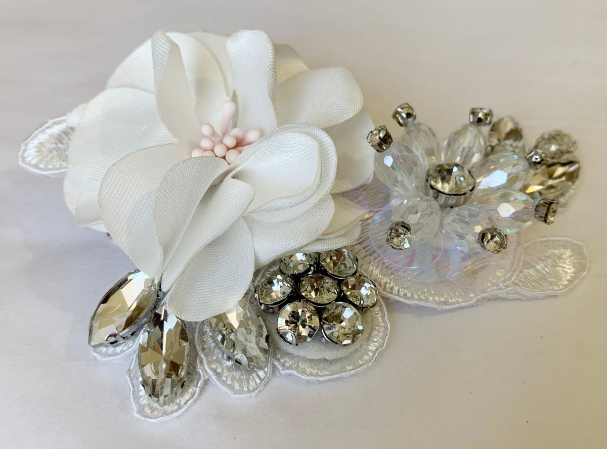 Off white rhinestone floral flower girl hair clip, close-up, embellishment detail.