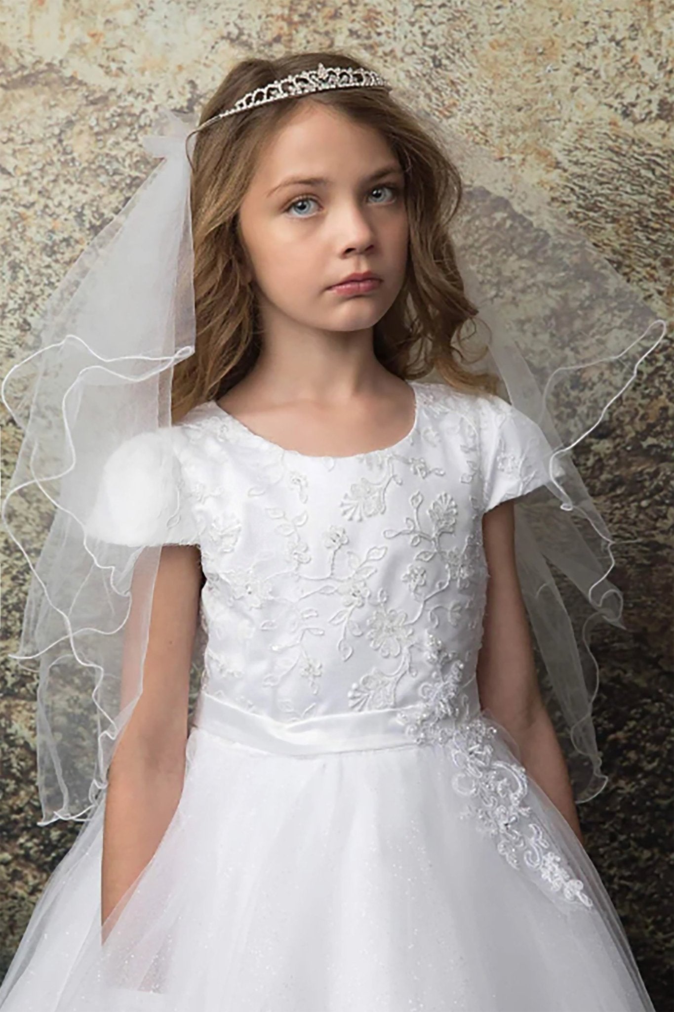 A white flower girl dress with lace details. Also suitable as a communion dress.