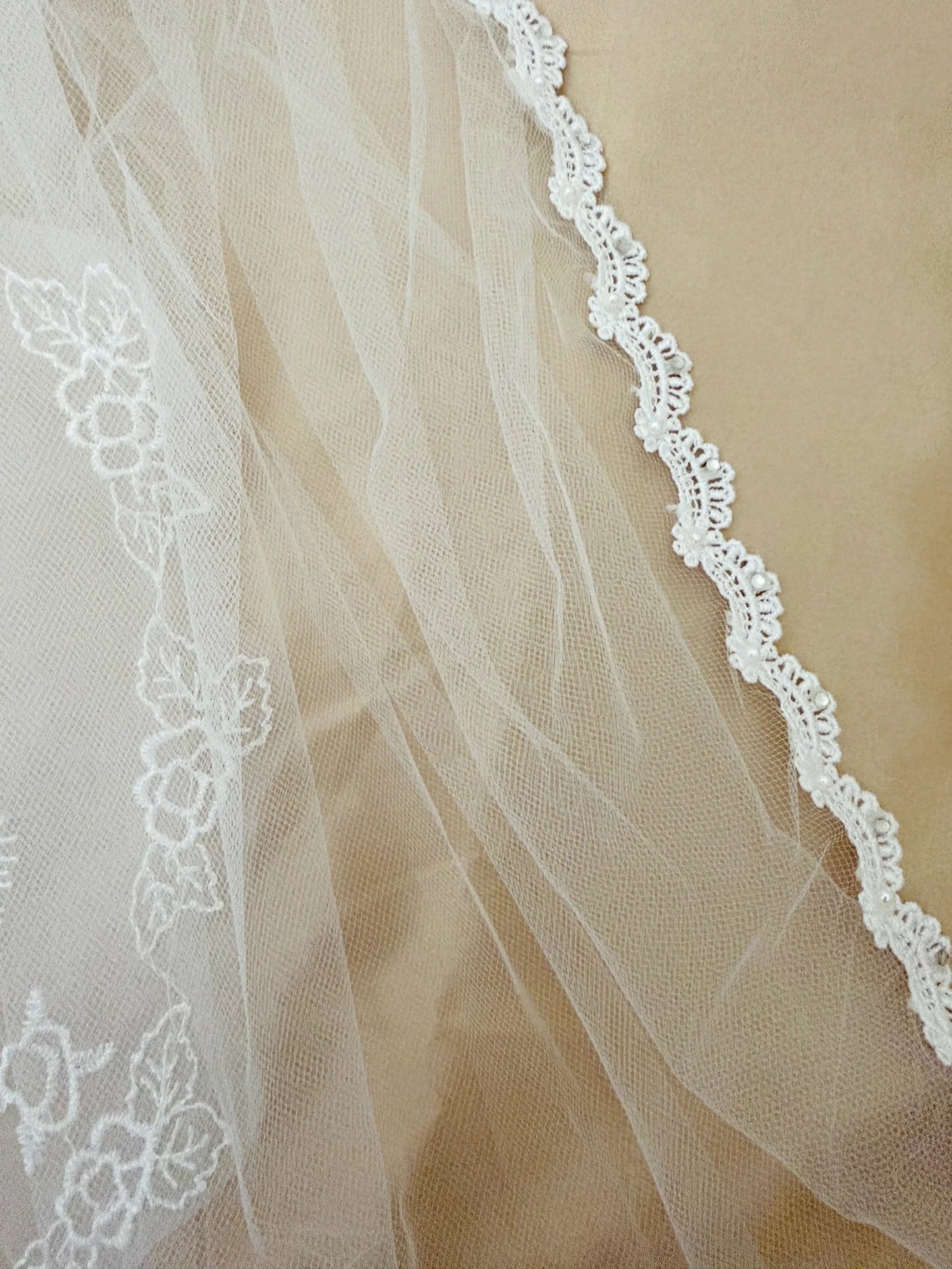 close up the communion veil that is fully trimmed with lace, rhinestones, and pearls
