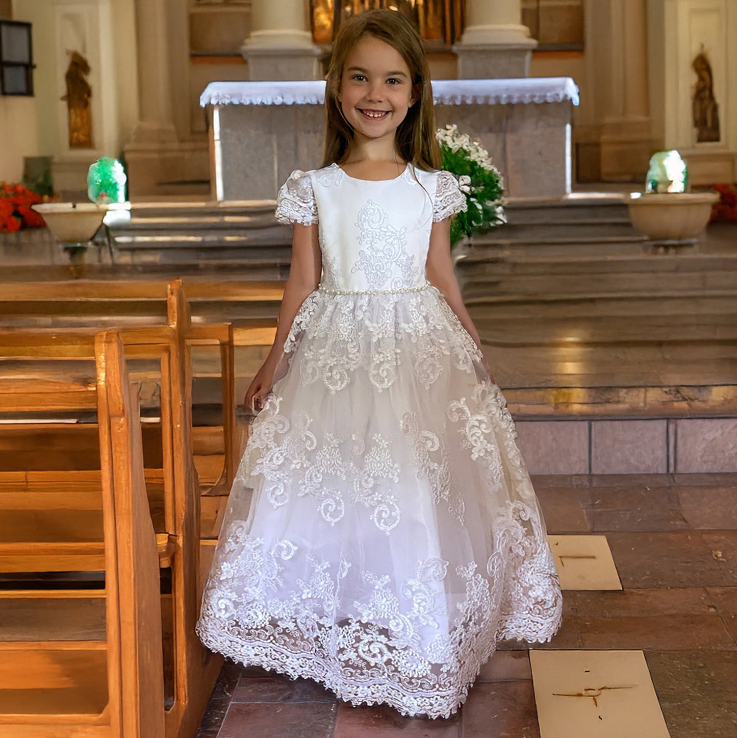Young girl in a white lace dress standing in a church.