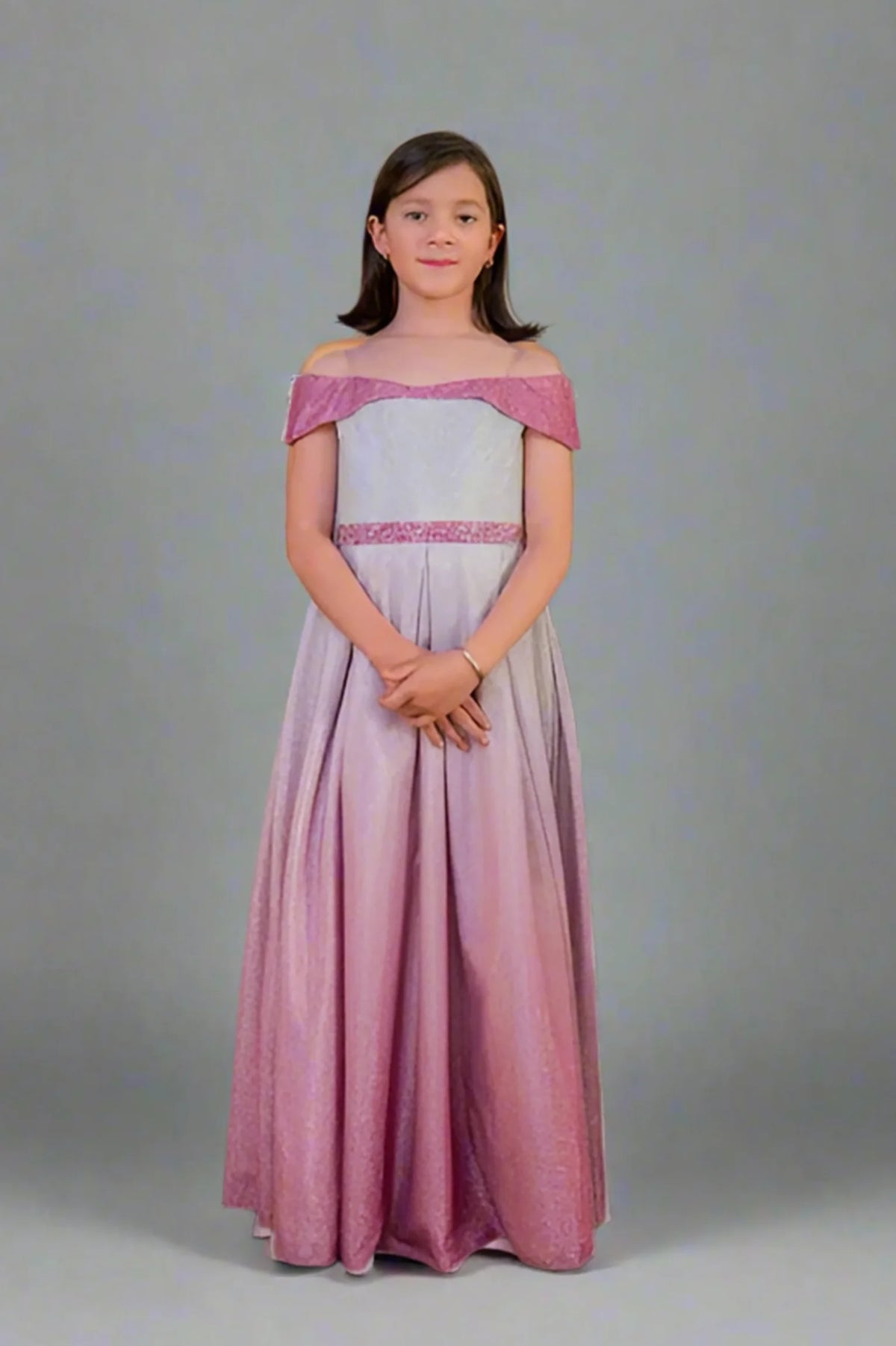 A graceful front view, the Pink/Silver mini quince dress showcases two-tone metallic ombre skirt and off-the-shoulder neckline with an oversized back bow.