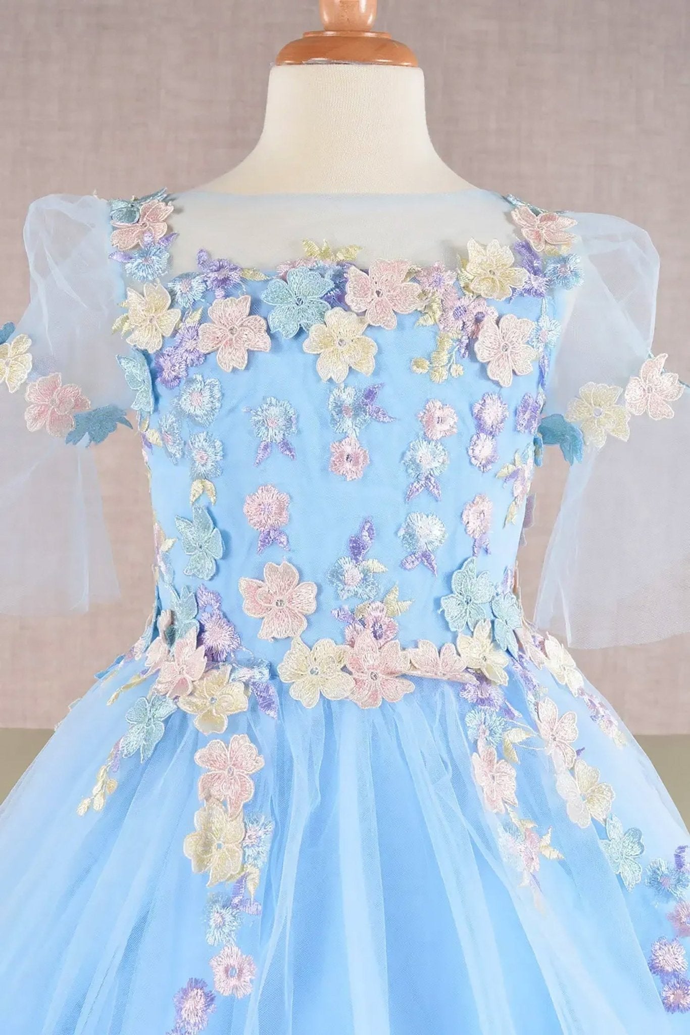 Front zoom view of a baby blue kid ballgown with 3D floral applique, puff sleeves
