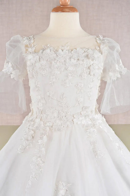 Detail view off-white kids mini quinceañera flower girl dress highlighting 3D floral appliques, mesh overlay and puff sleeve design. Also suitable as a mini quince dress. Also suitable as a communion dress.