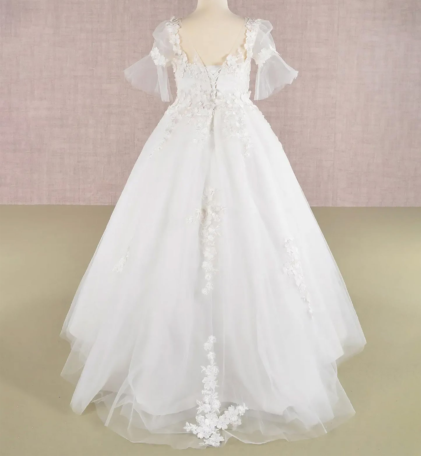 Back view off-white kids mini quinceañera flower girl dress with 3D floral appliques, puff sleeves and dramatic sweep train and lace back up. Also suitable as a mini quince dress. Also suitable as a communion dress.