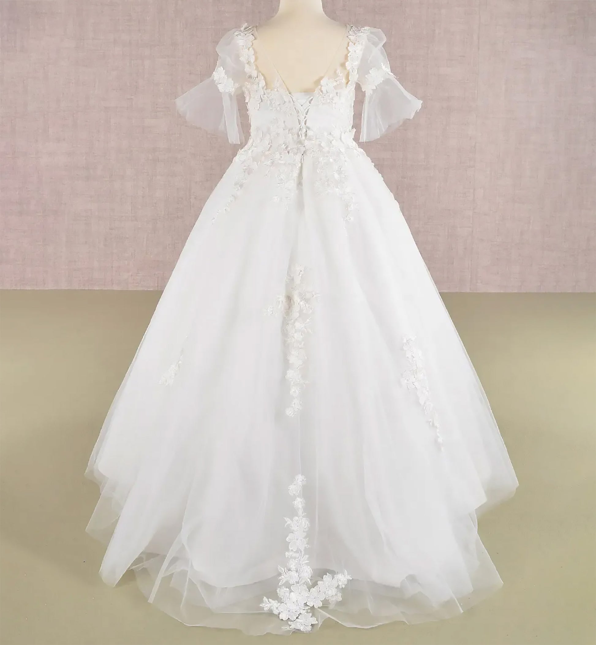 Back view off-white kids mini quinceañera flower girl dress with 3D floral appliques, puff sleeves and dramatic sweep train and lace back up. Also suitable as a mini quince dress. Also suitable as a communion dress.