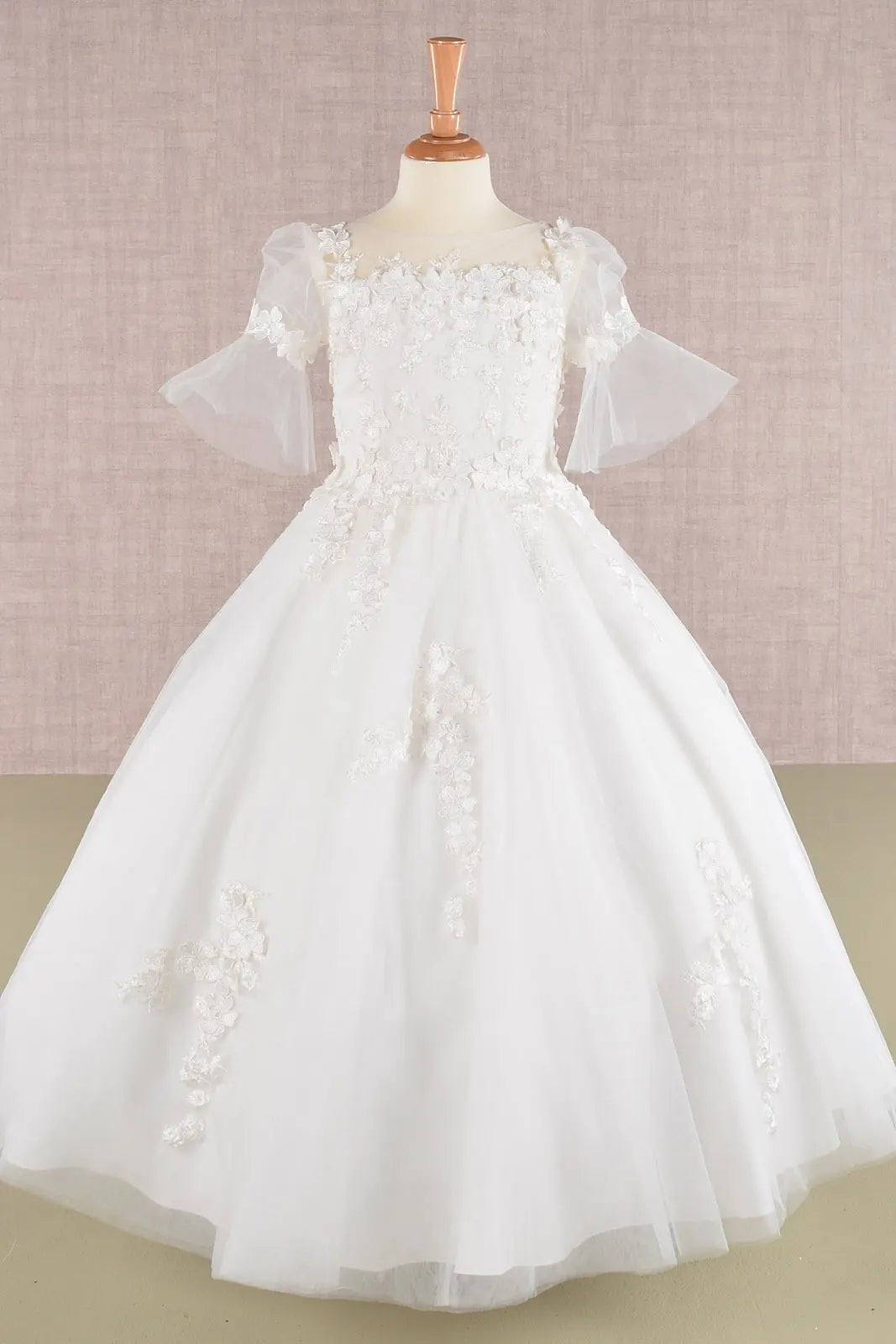 Front view off-white kids mini quinceañera flower girl dress with 3D floral appliques, puff sleeves and mesh overlay. Also suitable as a mini quince dress. Also suitable as a communion dress.