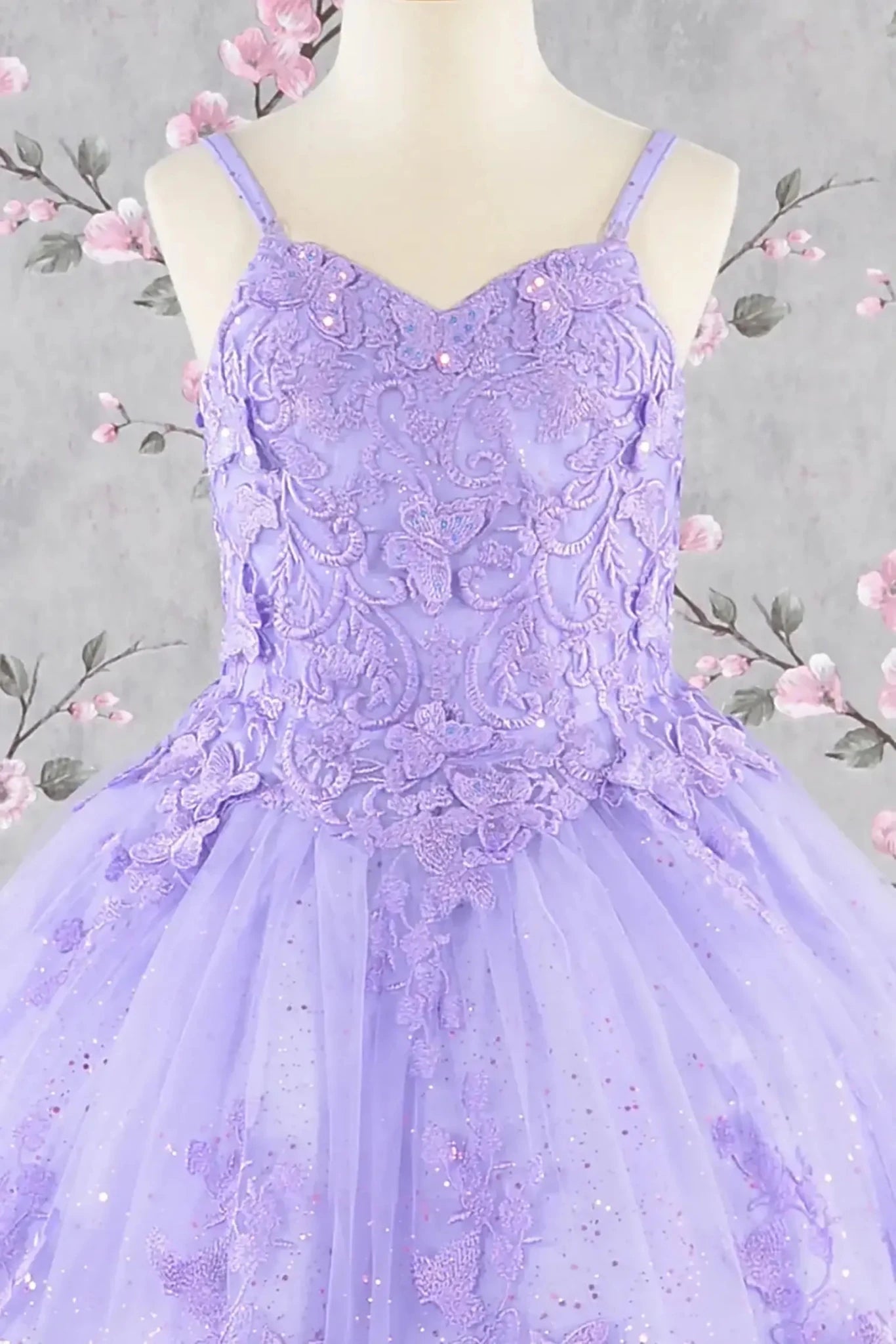 Front view of lilac kids mini quinceañera mini quince dress with 3D butterfly appliques, sequin-embellished bodice, glitter tulle skirt, and flowing mesh cape.