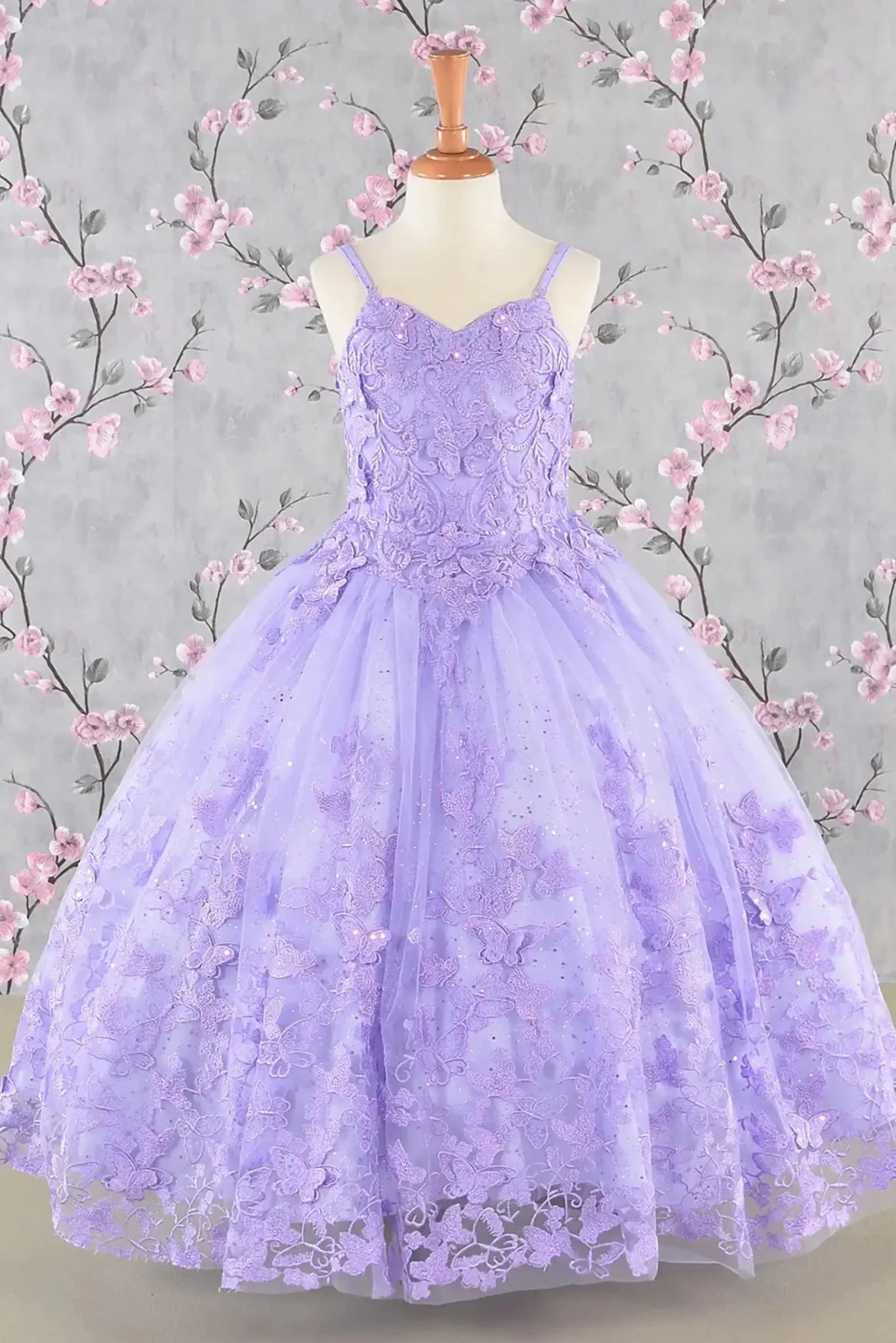 Front view of lilac kids mini quinceañera mini quince dress with 3D butterfly appliques, sequin-embellished bodice and glitter tulle skirt.