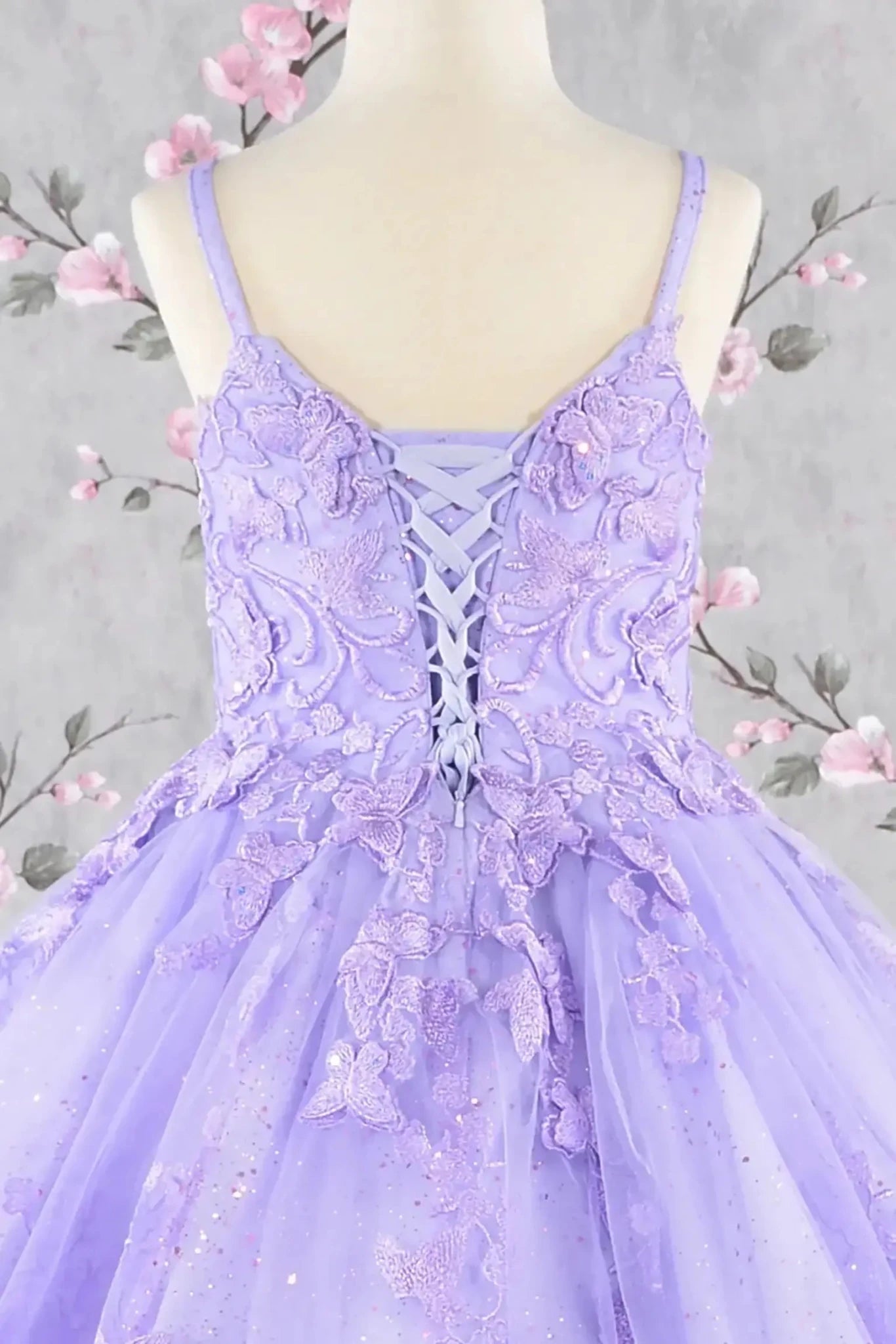 Front view of lilac kids mini quinceañera mini quince dress with 3D butterfly appliques, lace up bodice, glitter tulle skirt.