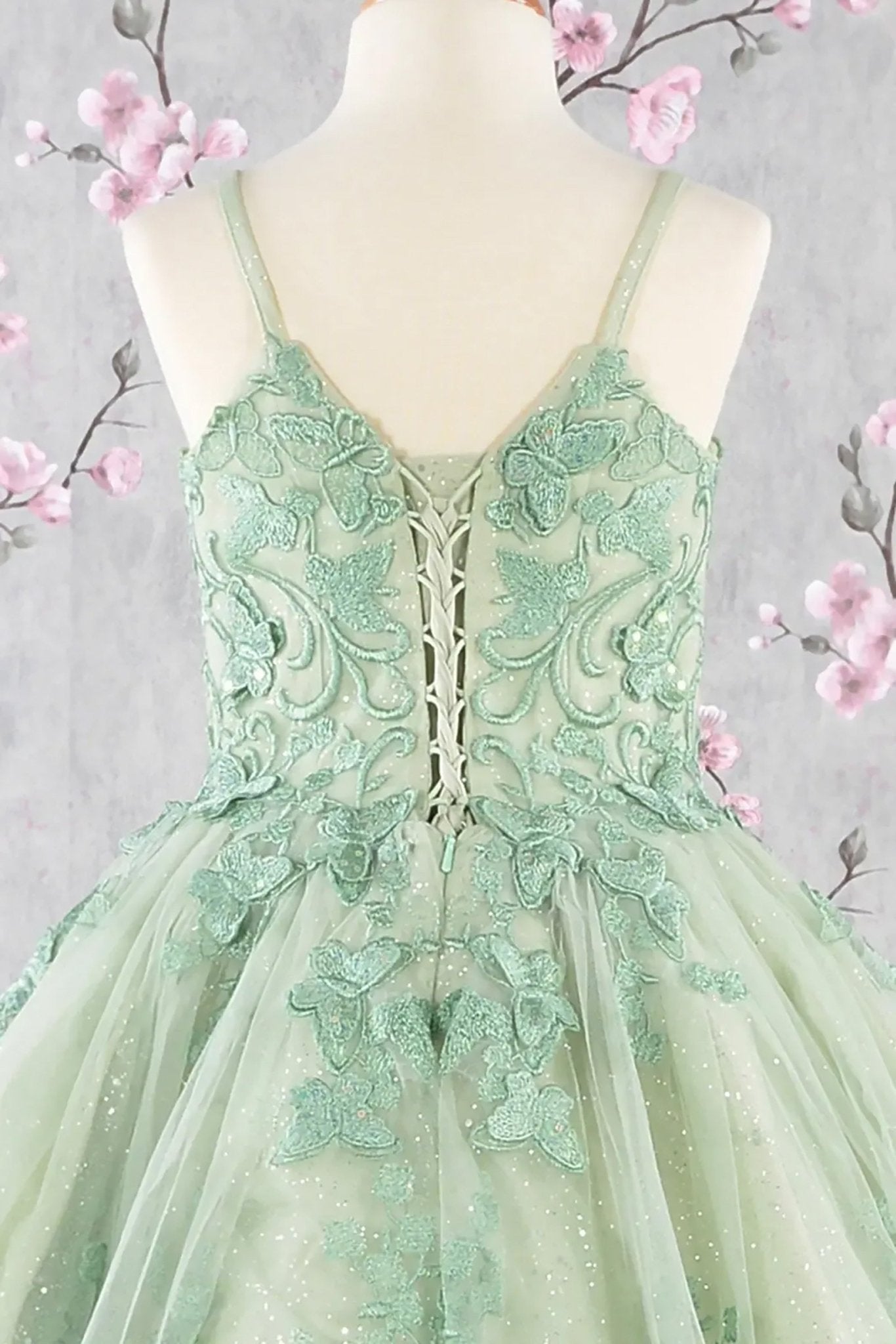 Back zoom view of a sage green kids mini quince dress with 3D butterflies, sequins, and detachable mesh cape.