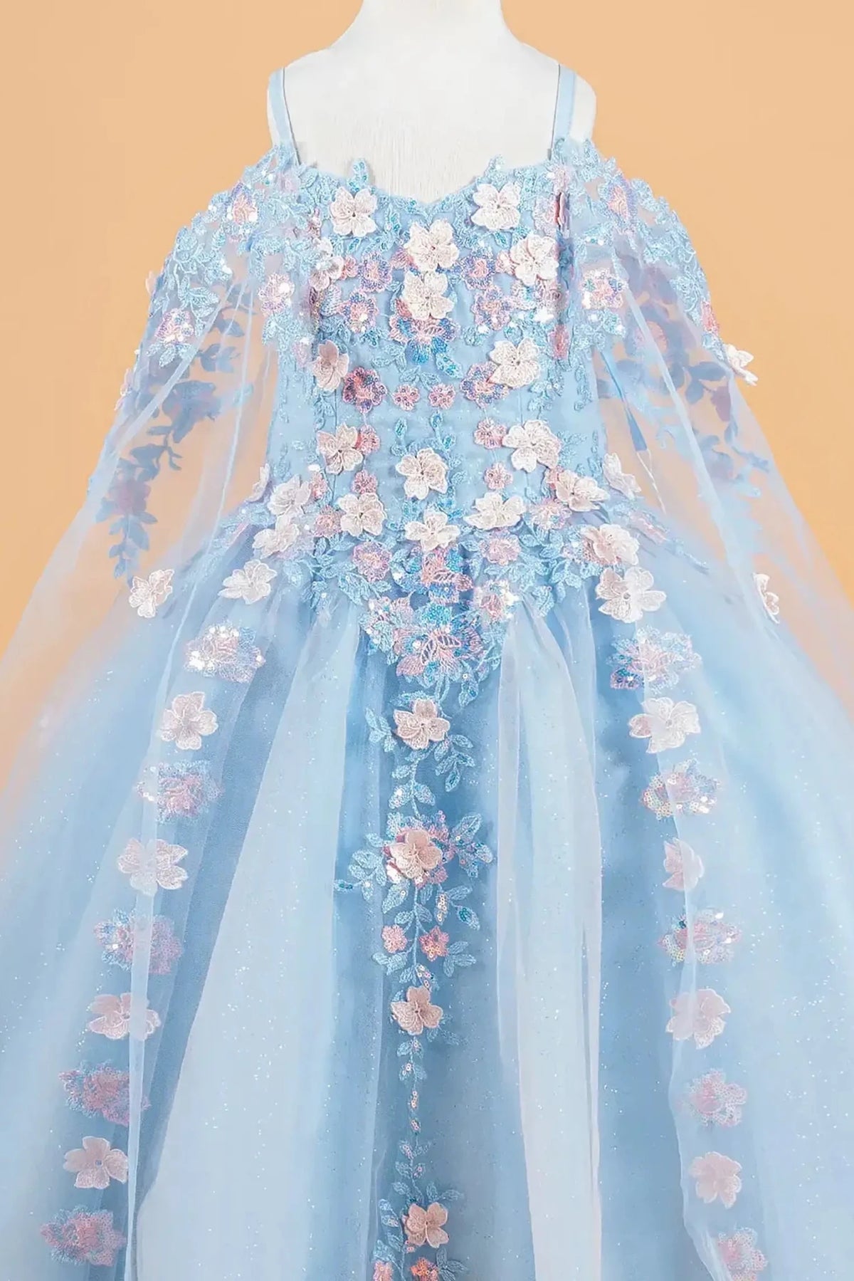 Blue kids mini quinceañera mini quince dress with 3D floral applique bodice, cold shoulder sleeves, glitter tulle skirt, and sheer cape overlay.
