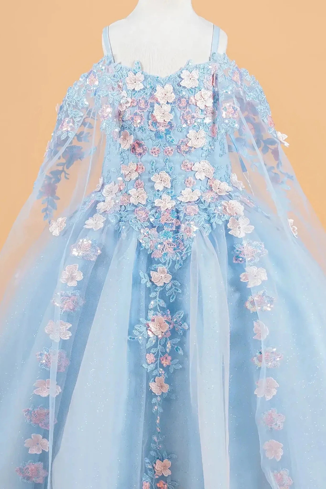 Blue kids mini quinceañera mini quince dress with 3D floral applique bodice, cold shoulder sleeves, glitter tulle skirt, and sheer cape overlay.
