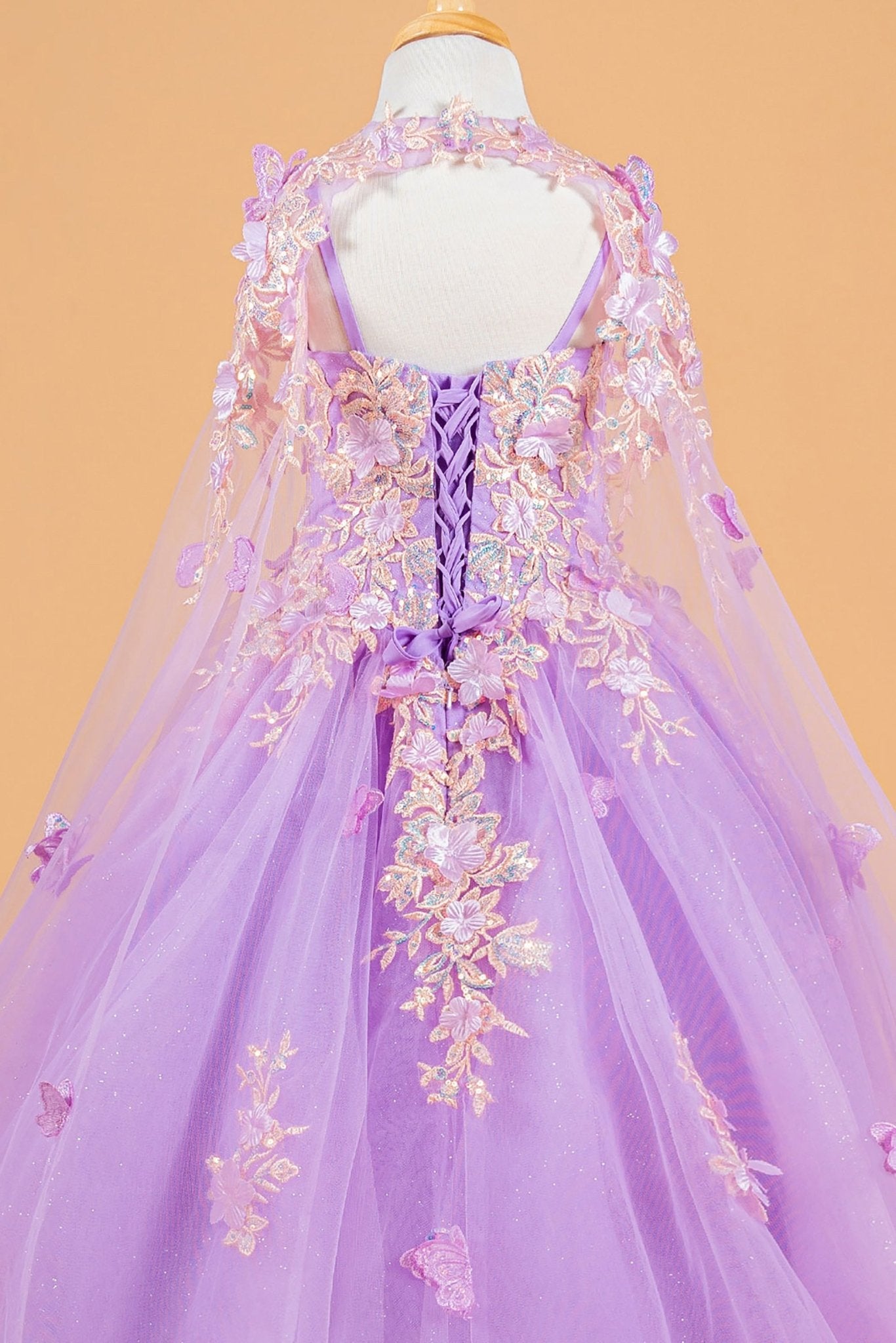 Back zoom view of a lilac kids mini quinceañera mini quince dress highlighting 3D flower and butterfly appliques with matching tunic.