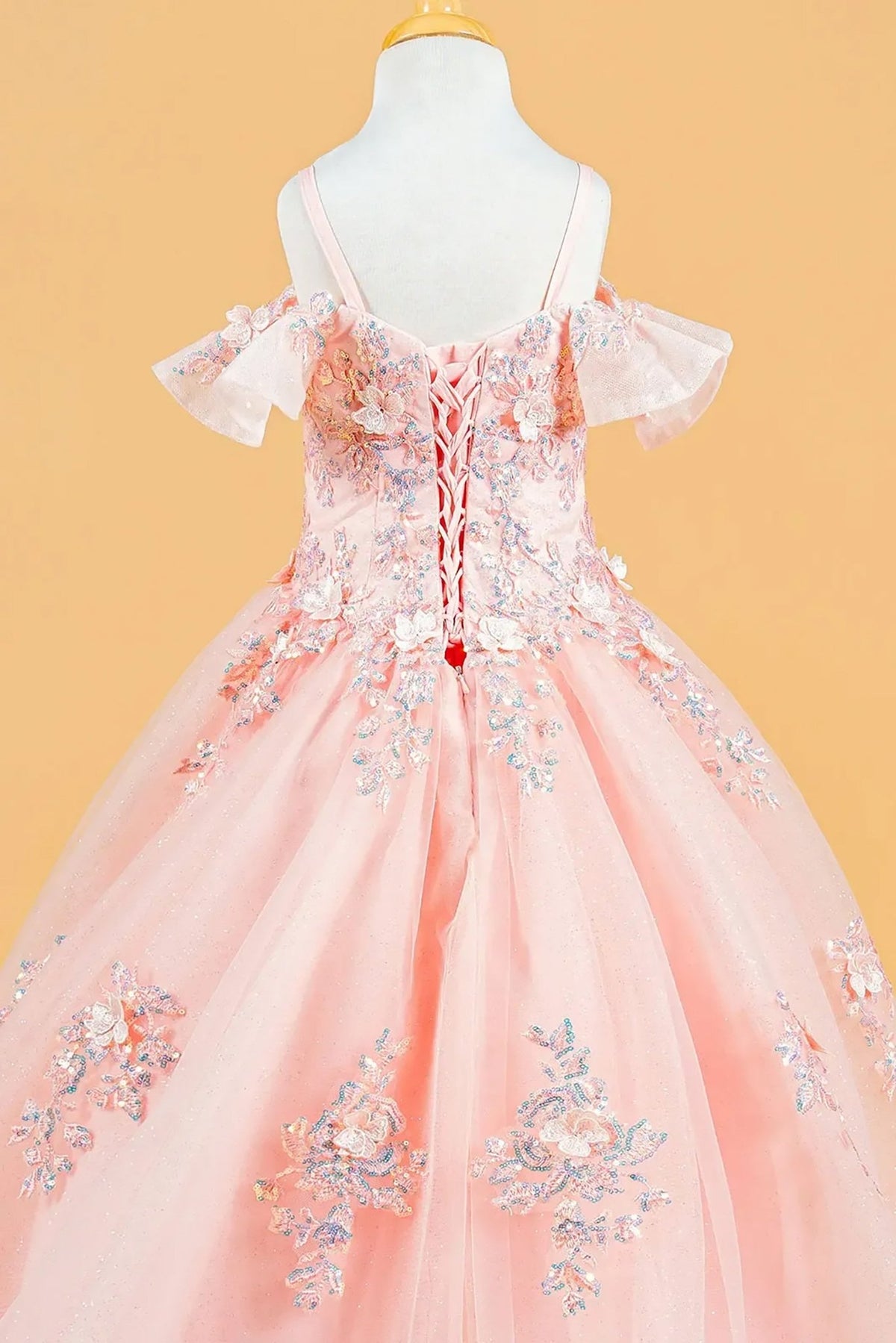 Back zoom view of a blush kids cold shoulder mini quince dress featuring 3D flowers, sequins, and lace-up back.