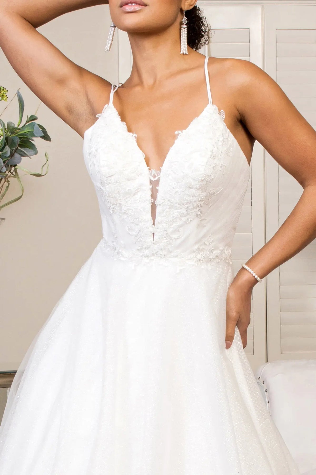 Floral embroidery surrounds the illusion sweetheart neckline on the ivory wedding gown.