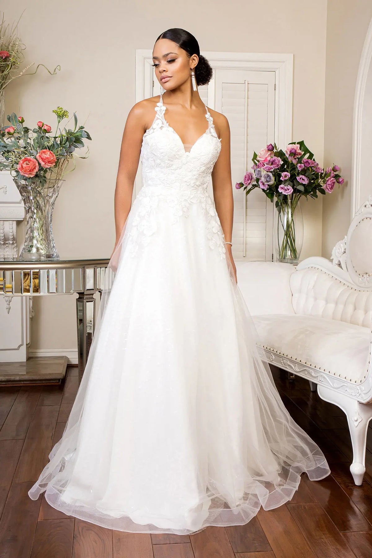 White wedding gown with floral embroidery flowing from the V-neck bodice into an A-line skirt.