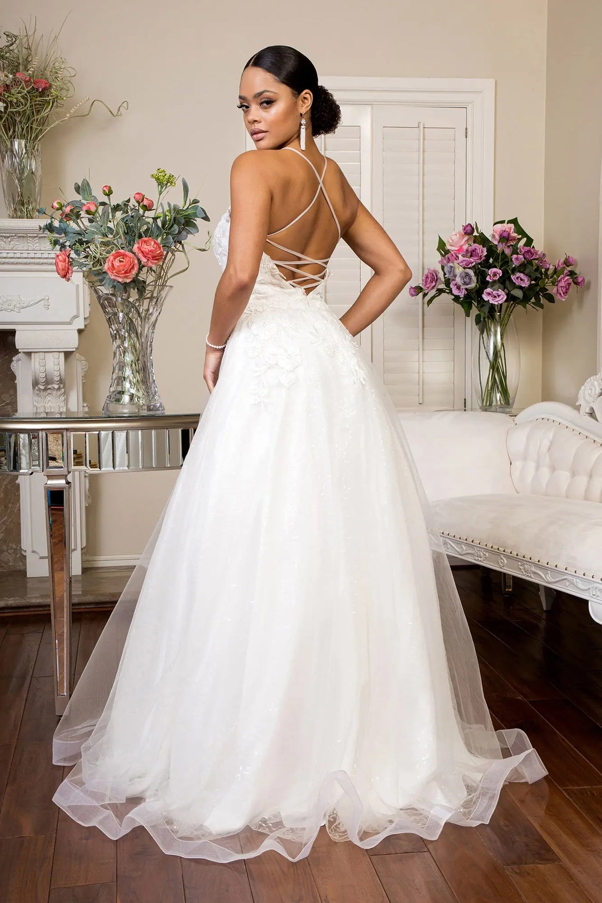 Crisscross lacing defines the open back of this white wedding gown.