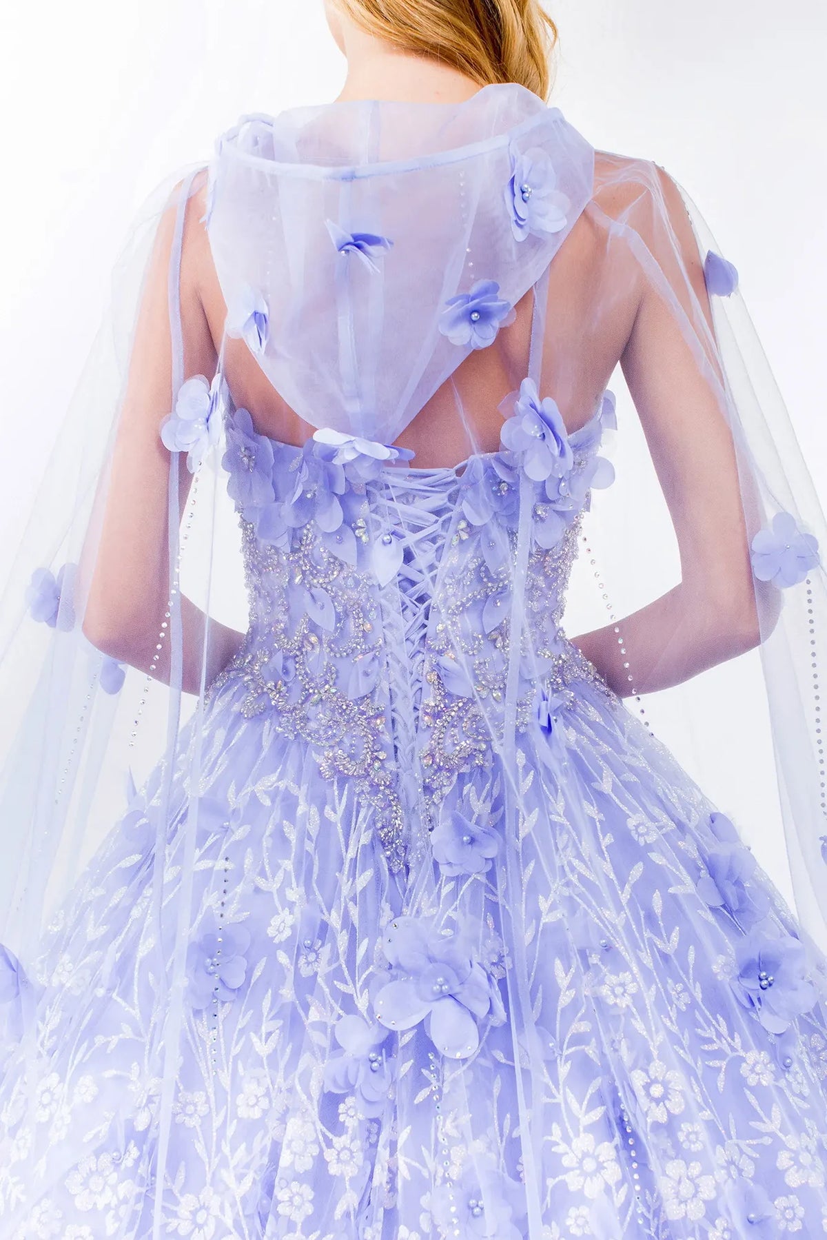 Layered skirt showcases the Lilac quinceañera ball gown with 3d floral cape.