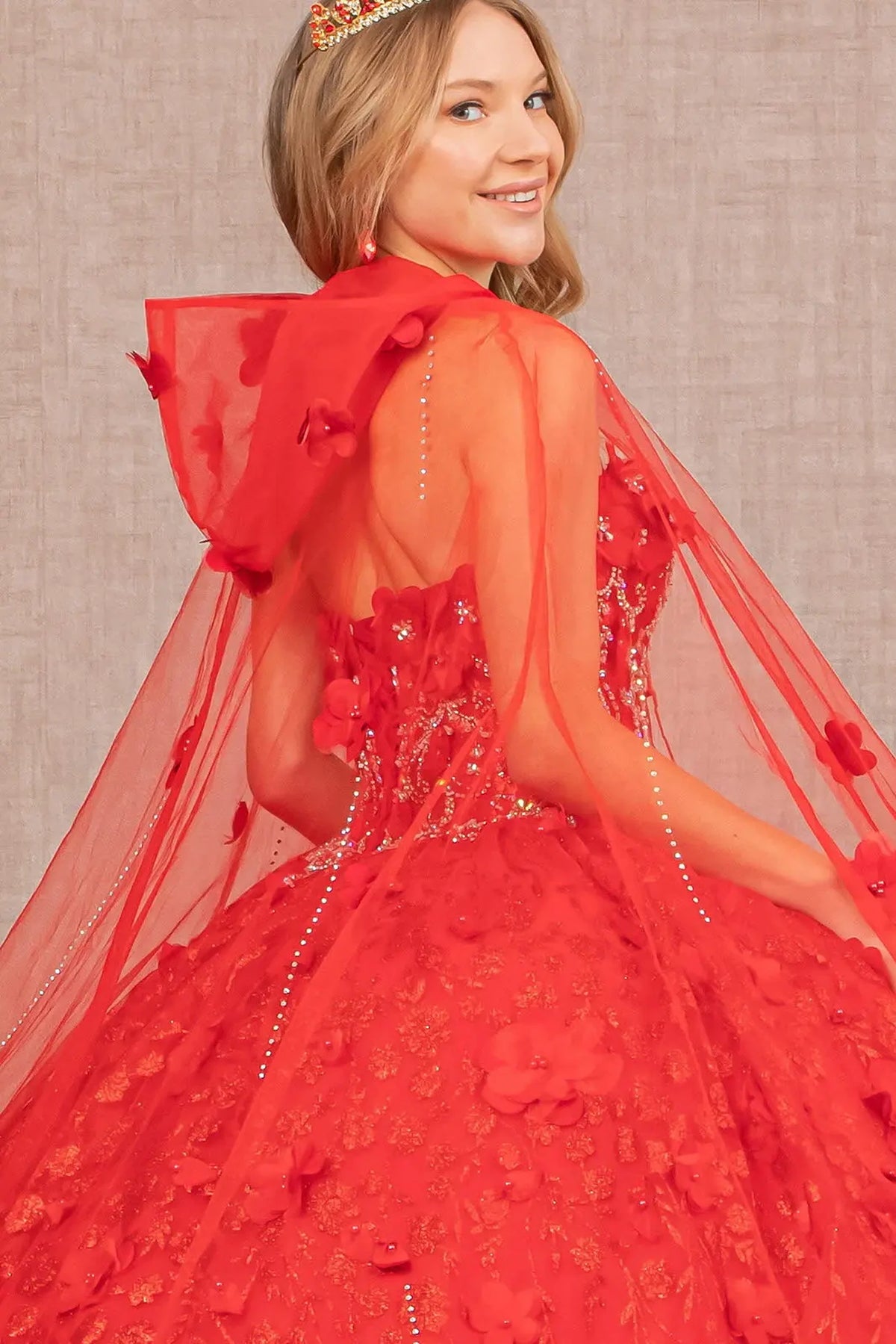 Embroidered details frame the Red quinceañera ball gown with 3d floral cape.