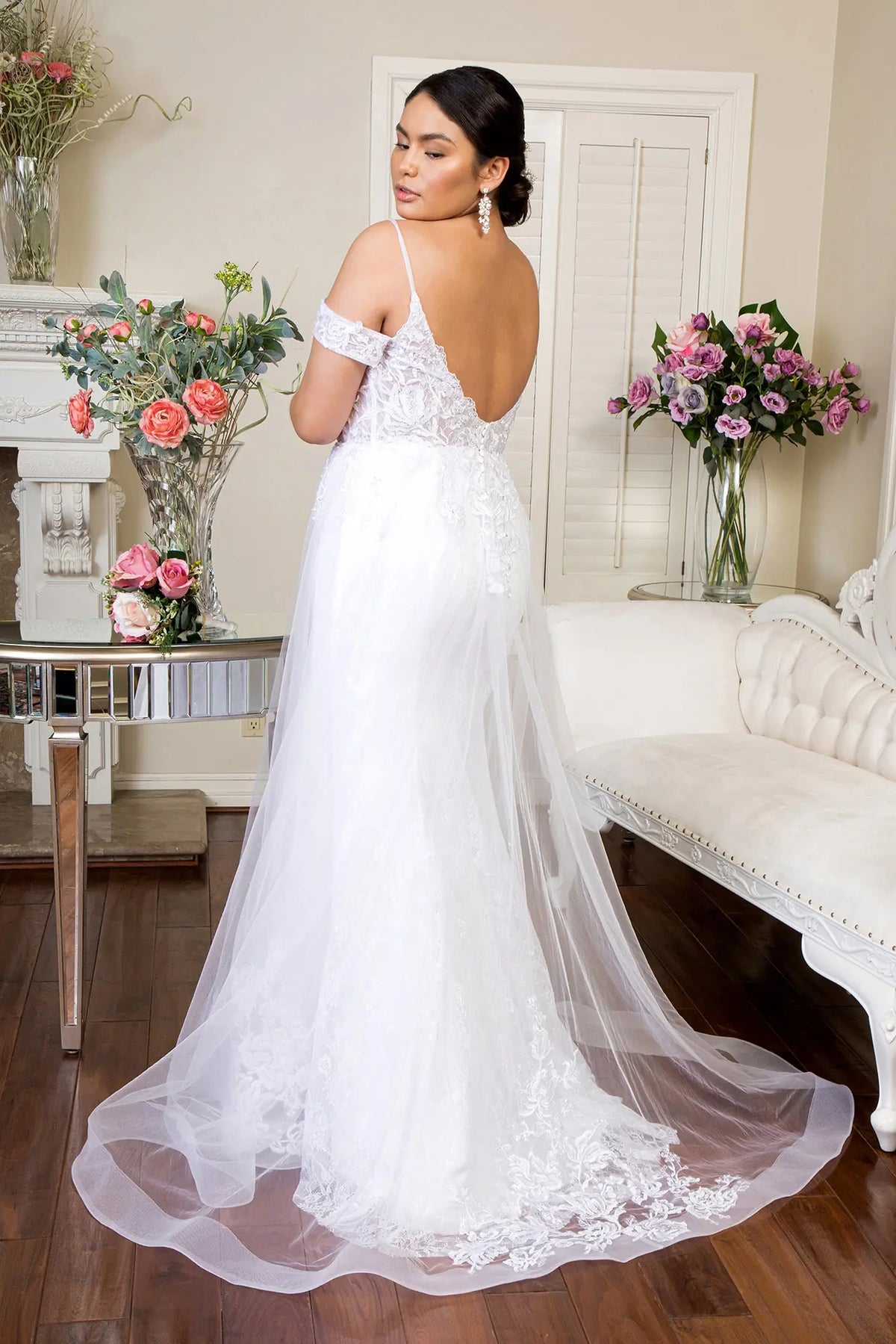 A deep V-back leads into the airy embroidered train of the white wedding gown.