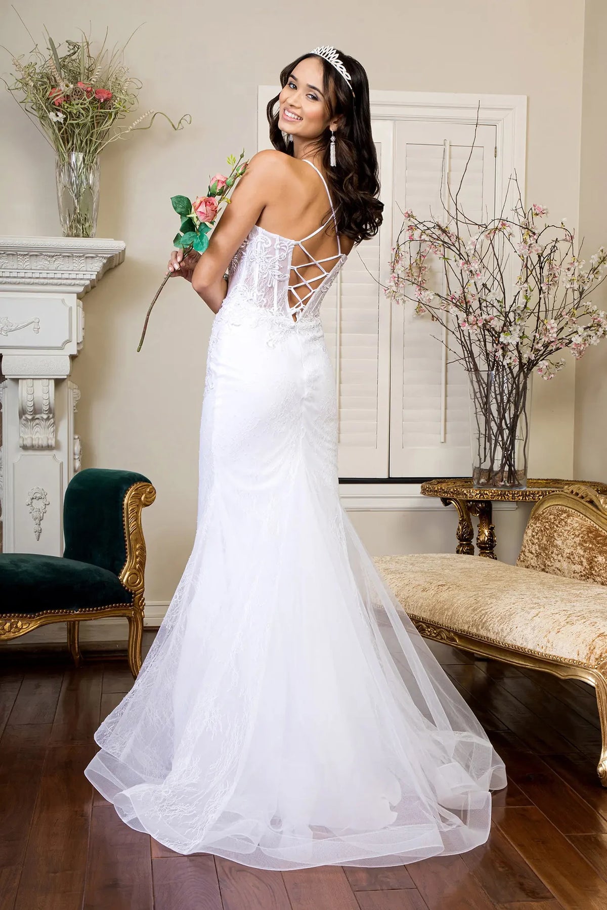 Lace-up straps cross the open back above the white wedding gown's layered train.