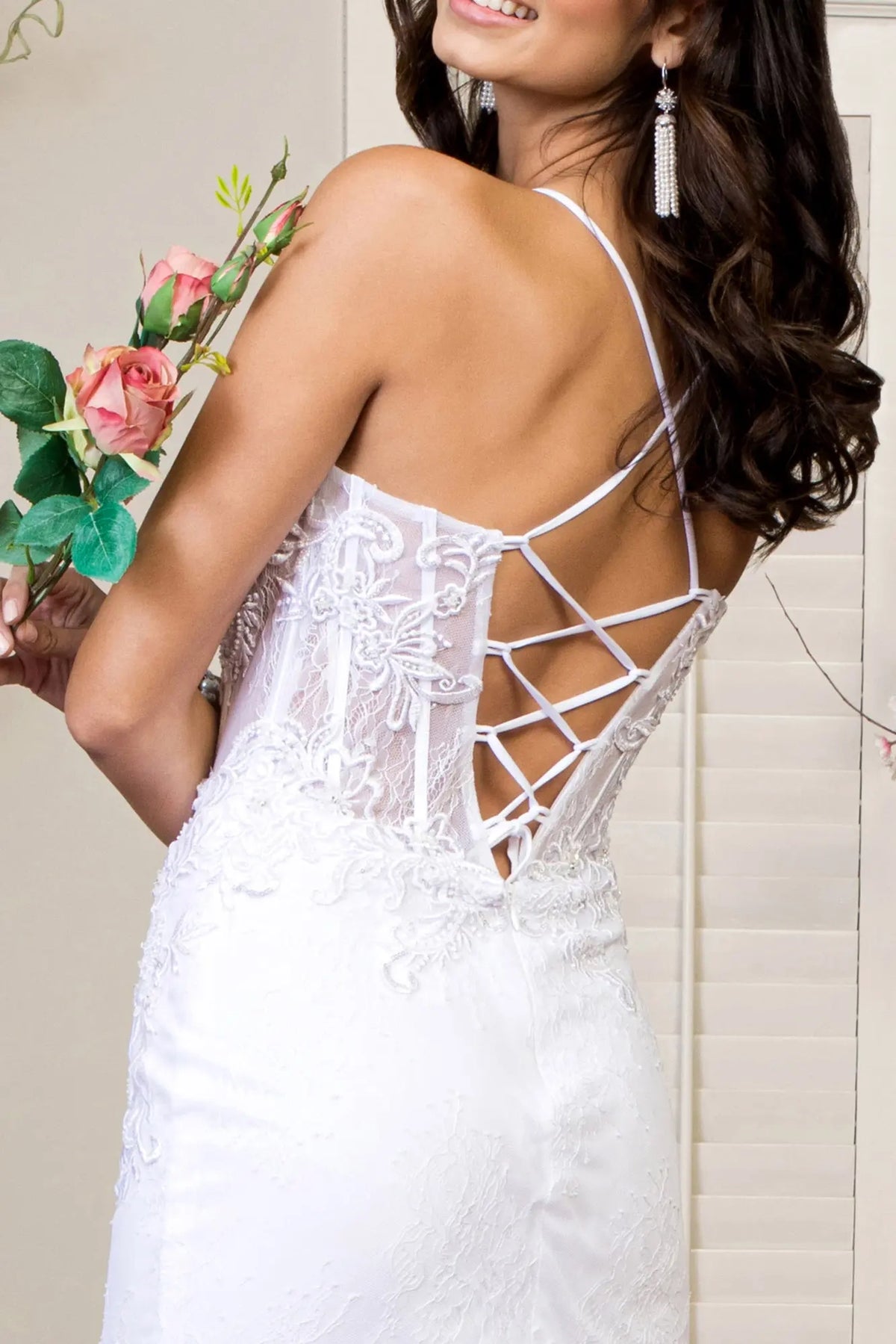 A crisscross corset fastening shapes the open back of the white wedding gown.